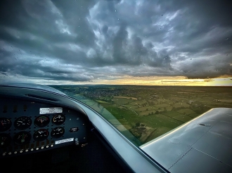 Storm brewing, by Ethan Sherry. Ethan over his home field of Kernan in Northern Ireland in the Sportcruiser owned by airfield owner Raphael O’Carroll.